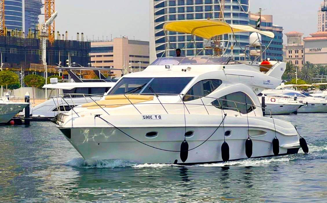 48ft Emerald Majesty luxury yacht cruising in the marina with city skyline background.