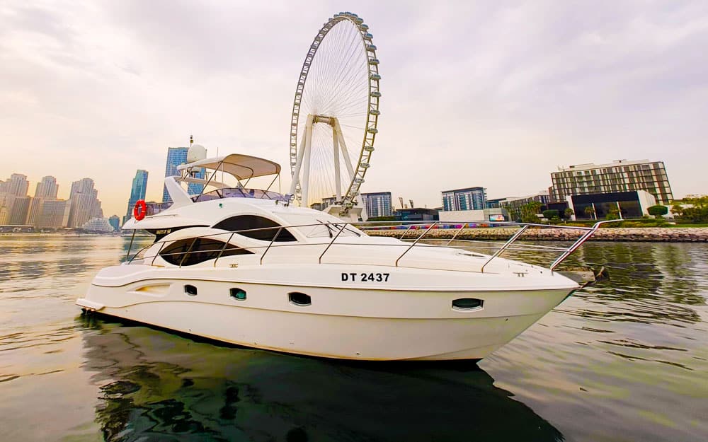Luxury 50ft Majesty Yacht (DT 2437) cruising in front of the Ain Dubai ferris wheel at sunset.