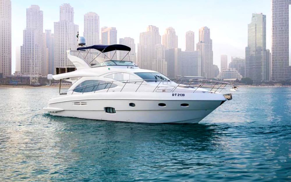 Side profile of the 56FT Majesty Yacht (DT 2139) cruising against the Dubai Marina skyline.